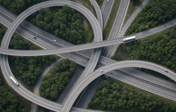 Vista aérea de um entroncamento rodoviário com caminhões de carga.